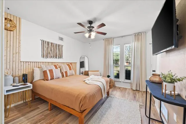 a spacious bedroom with a bed and a flat screen tv