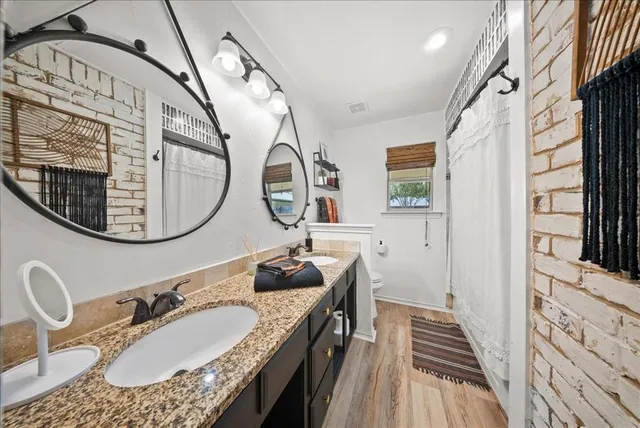 a bathroom with a granite countertop double vanity sink and a mirror