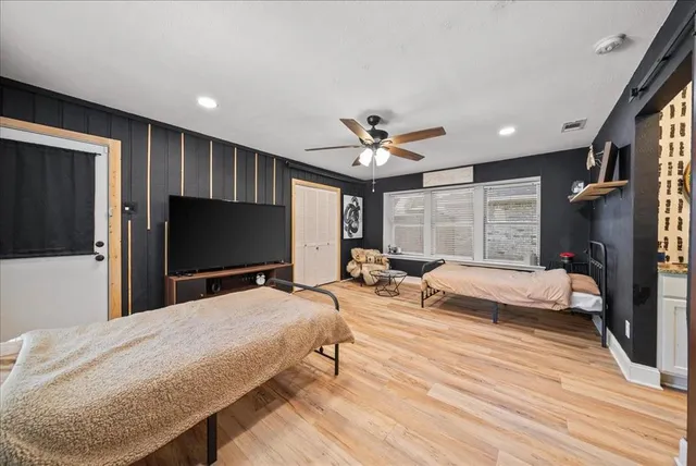 a spacious bedroom with a bed and a flat screen tv