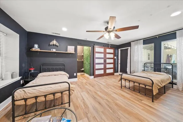 a bedroom with a bed a chandelier and a fireplace