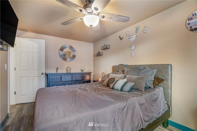 a bedroom with a large bed and a flat tv screen on dresser