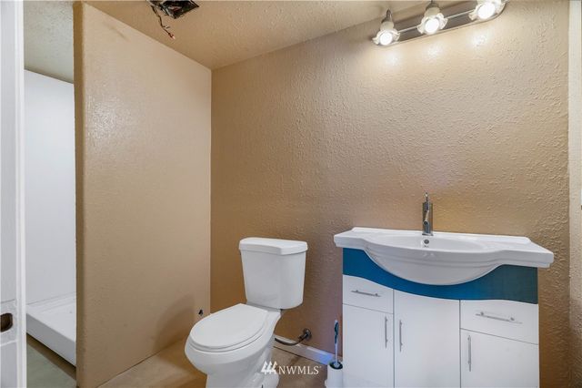 a bathroom with a toilet a sink and mirror