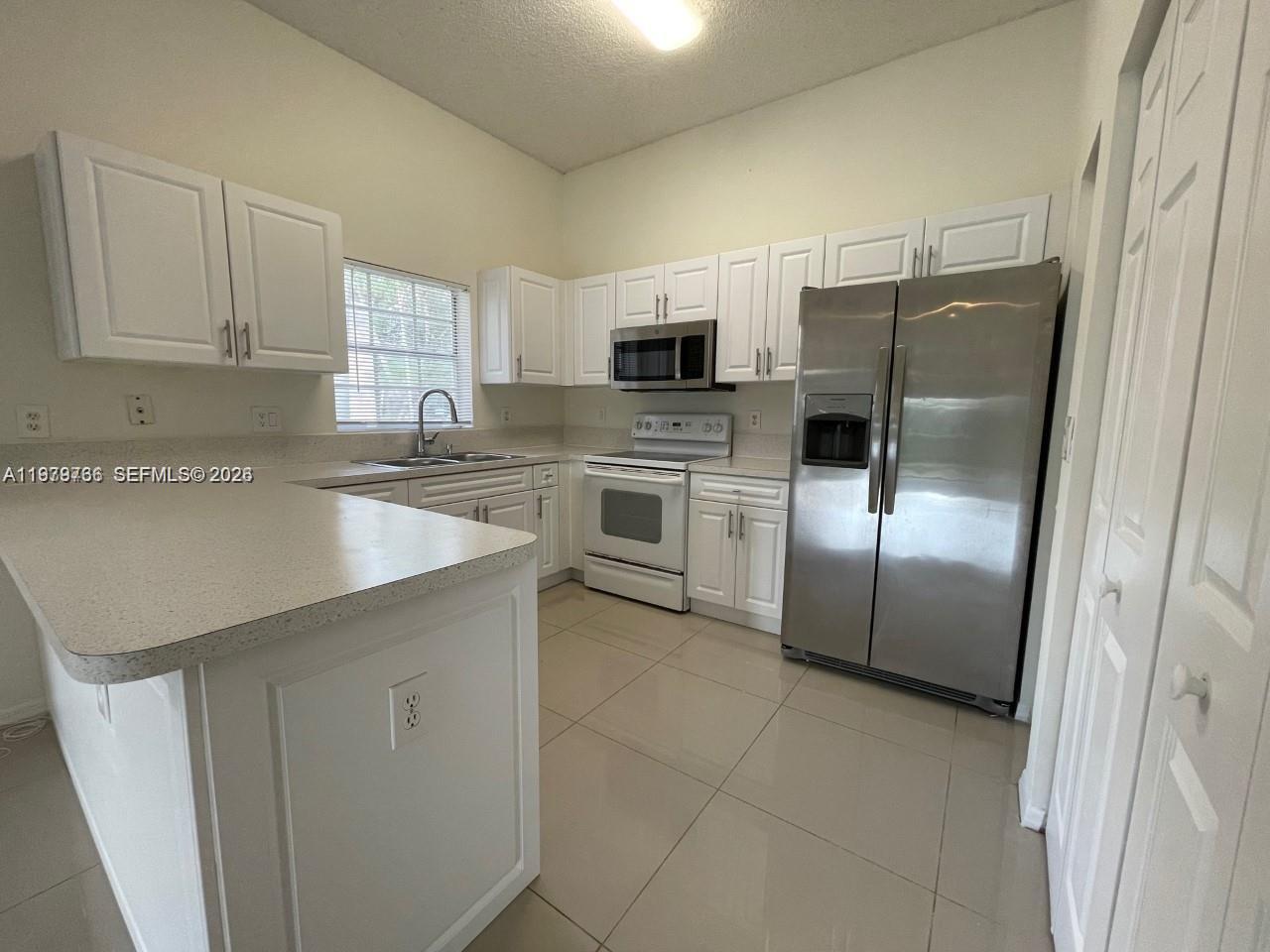 16309 Emerald Cove Road, Unit 16309 Weston, FL 33331 - Photo 12 of 41 a kitchen with stainless steel appliances a refrigerator sink and microwave