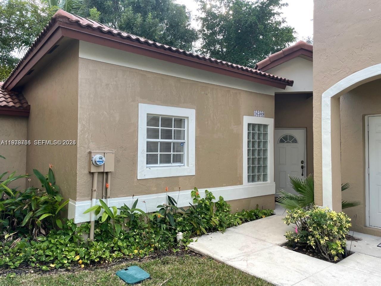 16309 Emerald Cove Road, Unit 16309 Weston, FL 33331 - Photo 3 of 41 a front view of a house with garden