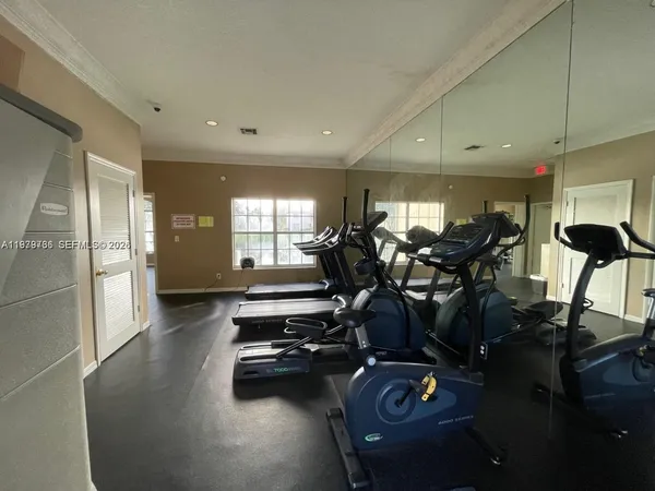 a view of a room with gym equipment and a large window