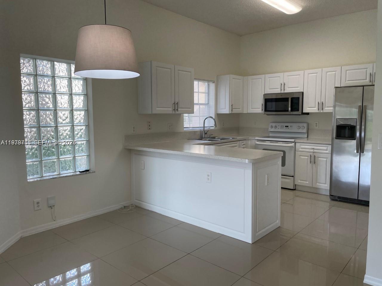 16309 Emerald Cove Road, Unit 16309 Weston, FL 33331 - Photo 8 of 41 a kitchen with stainless steel appliances granite countertop a stove a sink and a refrigerator