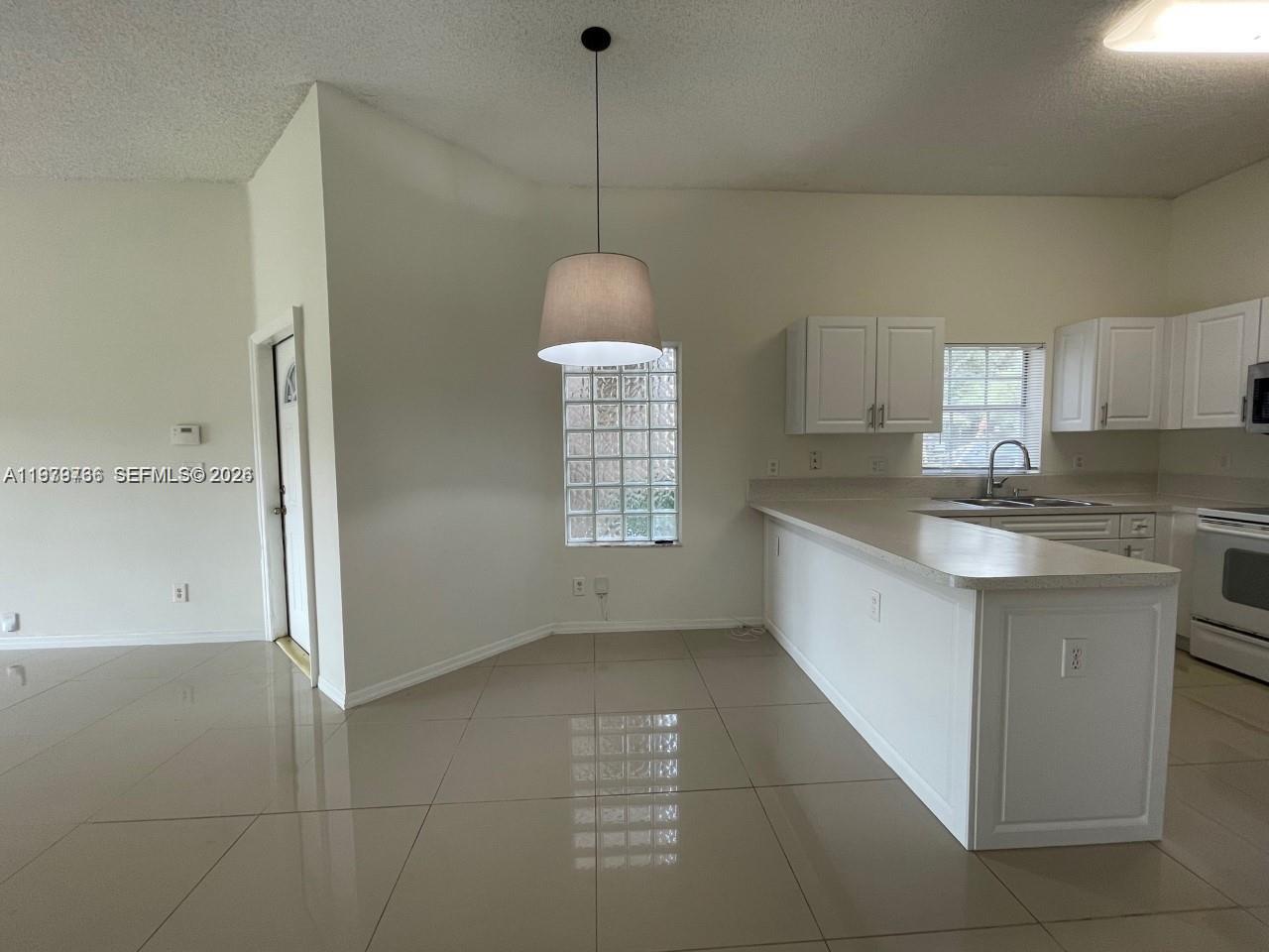 16309 Emerald Cove Road, Unit 16309 Weston, FL 33331 - Photo 10 of 41 a kitchen with a sink a refrigerator and window