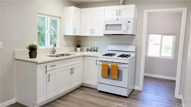 a kitchen with stainless steel appliances white cabinets and a stove top oven