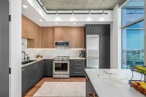 a kitchen with stainless steel appliances granite countertop a sink stove and refrigerator
