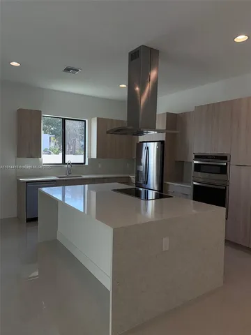 a kitchen with stainless steel appliances a sink a stove and a window