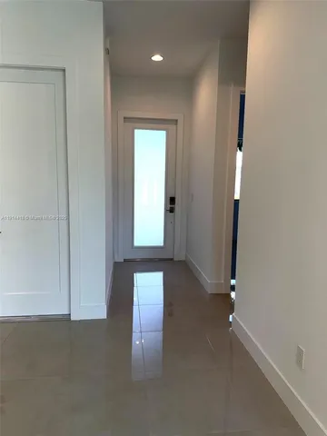 an empty room with wooden floor and entrance