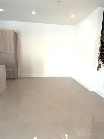 an empty room with wooden floor and entrance