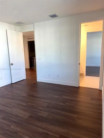 a view of a room with wooden floor