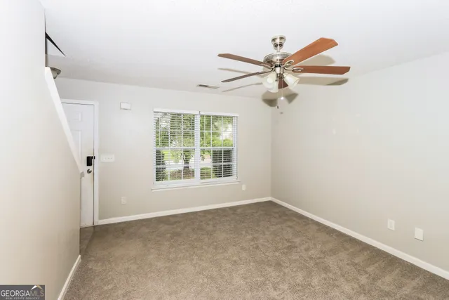 a view of a big room with a ceiling fan and a window