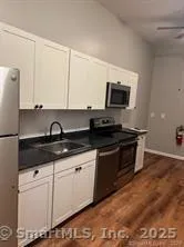 a kitchen with granite countertop a sink and a stove top oven