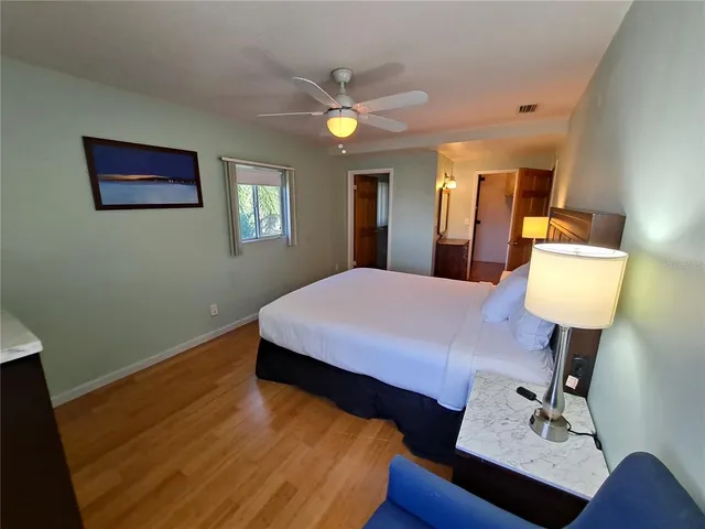 a bedroom with a bed and wooden floor