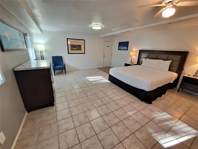 a bedroom with a bed and a lamp on dresser