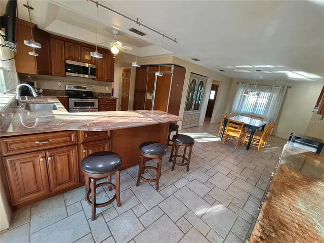 a kitchen with sink a stove and chairs