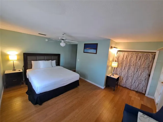 a bedroom with a bed and wooden floor