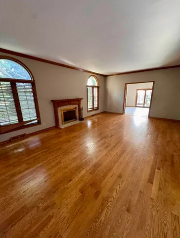 a view of an empty room and chandelier fan