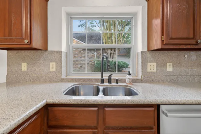 a kitchen with stainless steel appliances granite countertop a sink and a window