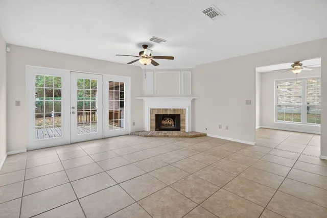 a view of an empty room with a fireplace and a window