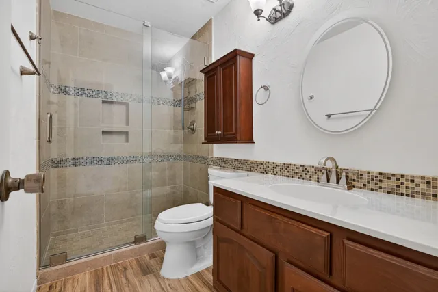 a bathroom with a sink a toilet and a mirror