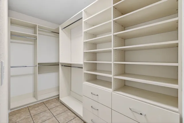 a view of walk in closet with empty racks