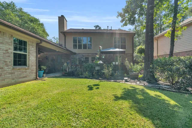 a view of a house with a backyard and a tree