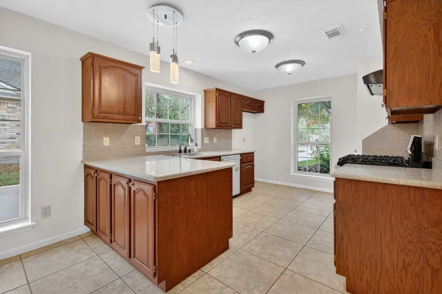 a kitchen with granite countertop a sink stove top oven and cabinets
