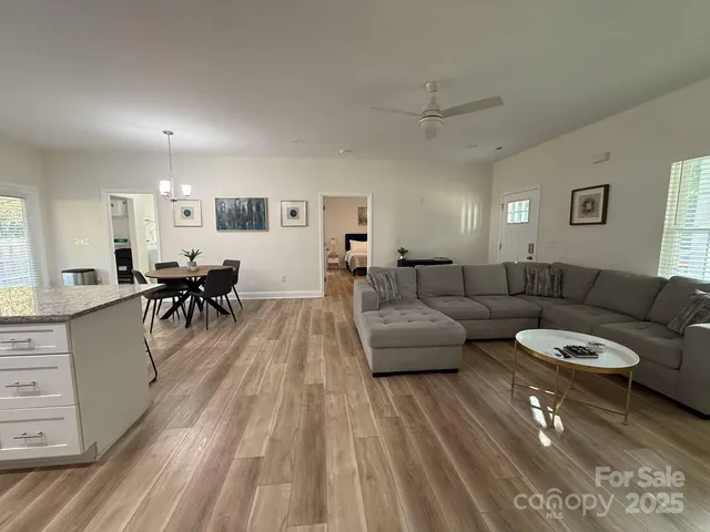 a living room with furniture and view of kitchen