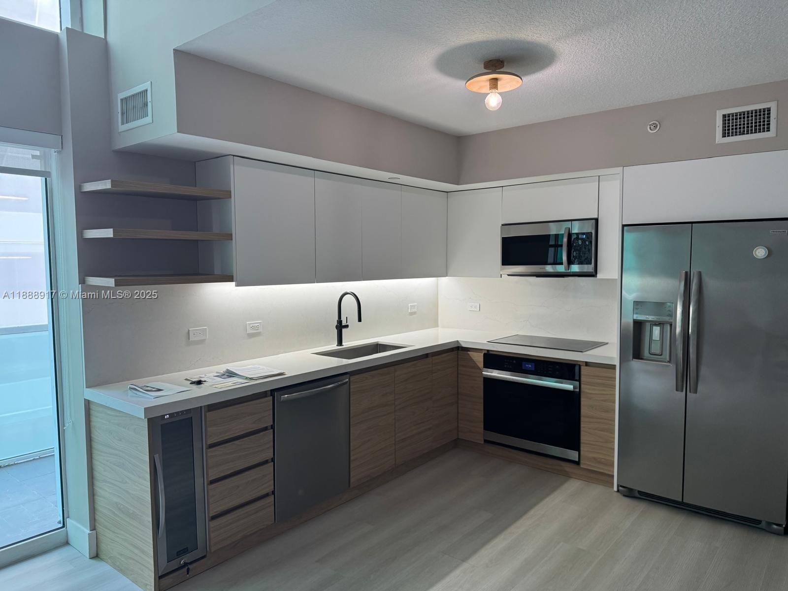 41 Southeast 5th Street, Unit 501 Miami, FL 33131 - Photo 26 of 36 a kitchen with a sink stainless steel appliances and cabinets