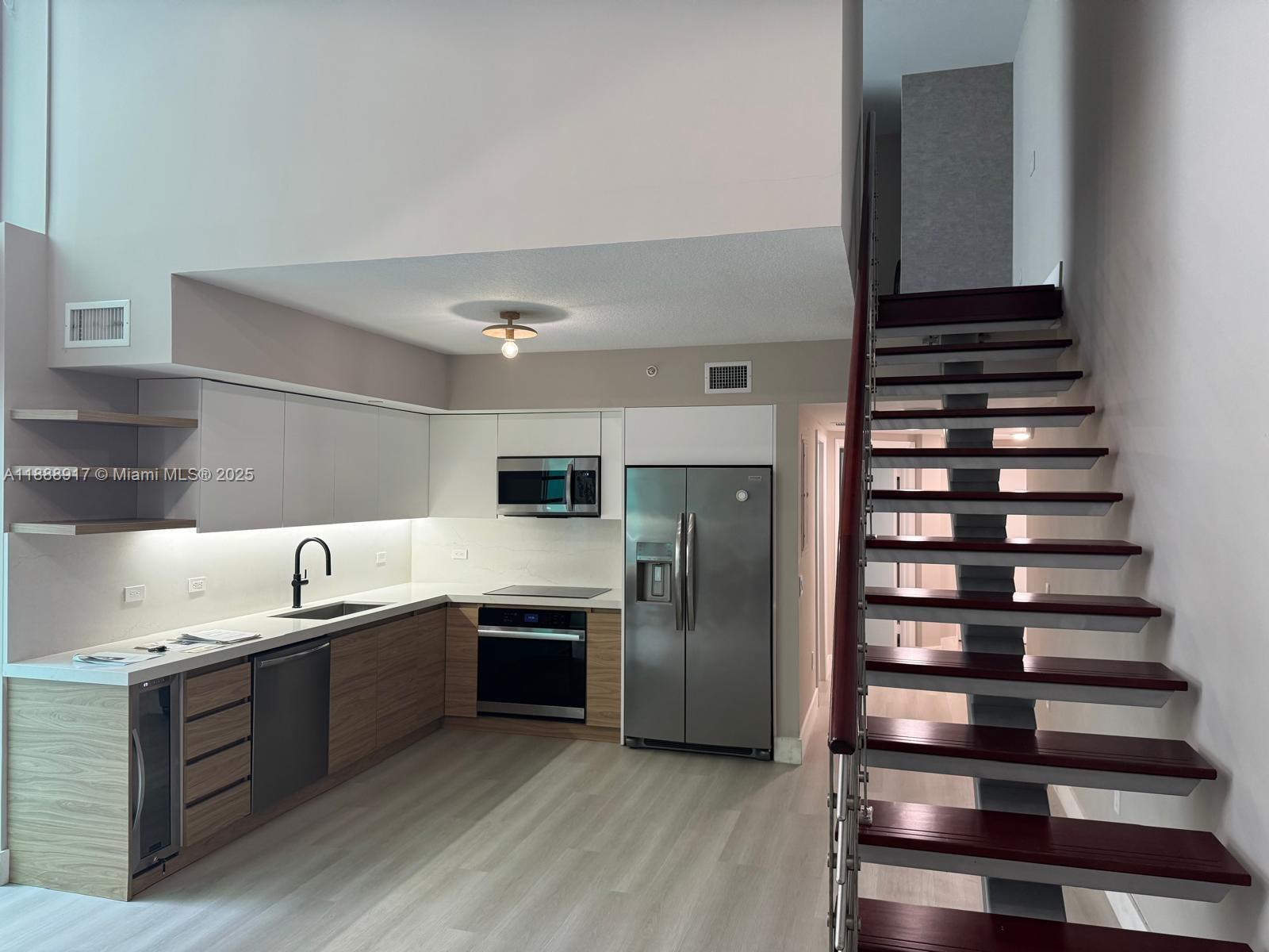 41 Southeast 5th Street, Unit 501 Miami, FL 33131 - Photo 29 of 36 a kitchen with granite countertop stainless steel appliances and wooden cabinets