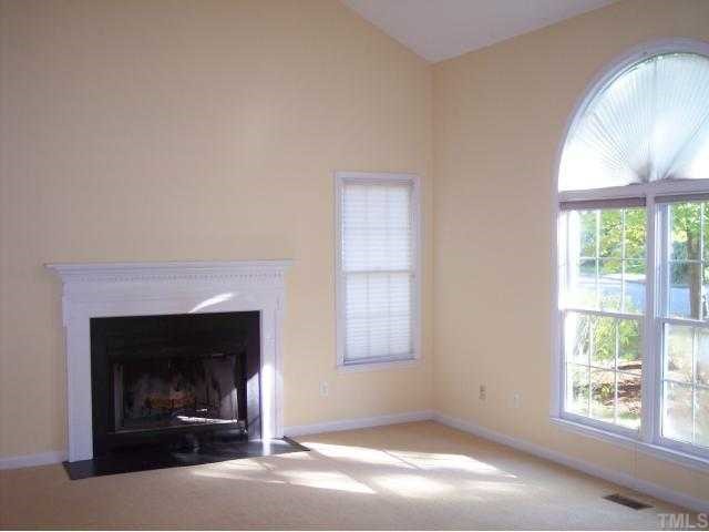 5154 Fairmead Circle Raleigh, NC 27613 - Photo 2 of 11 an empty room with a fireplace and windows