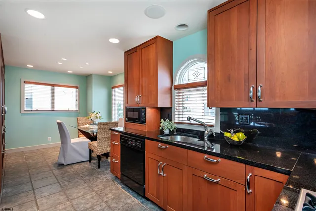 a kitchen with stainless steel appliances granite countertop a sink a stove cabinets and a counter top space