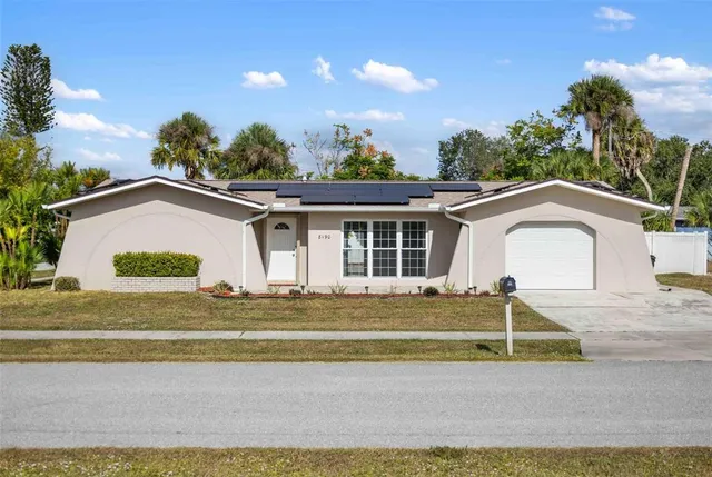 a view of a house with a backyard and a garage