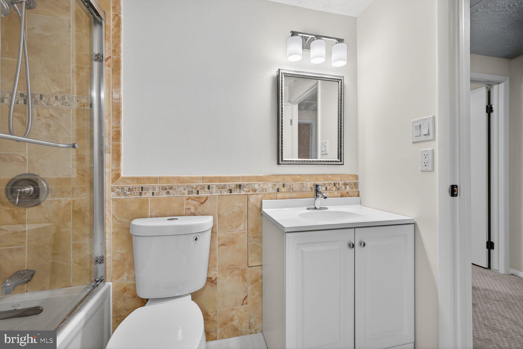 12515 Willow Spring Circle Germantown, MD 20874 - Photo 11 of 22 a bathroom with a toilet sink and mirror