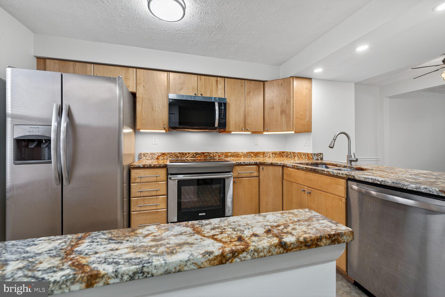 12515 Willow Spring Circle Germantown, MD 20874 - Photo 2 of 22 a kitchen with kitchen island granite countertop a stove sink and refrigerator