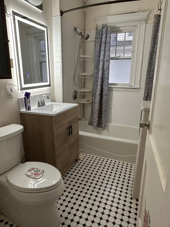 a bathroom with a sink a toilet a mirror and shower