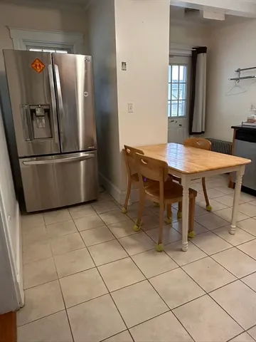 a kitchen with stainless steel appliances a table chairs and a refrigerator