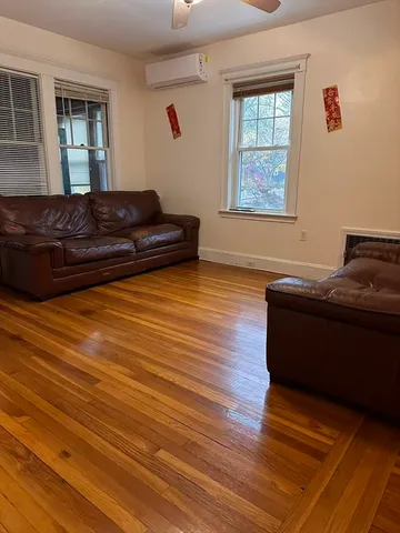 a living room with wooden floor and furniture