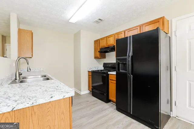 a kitchen with stainless steel appliances granite countertop a refrigerator and a sink
