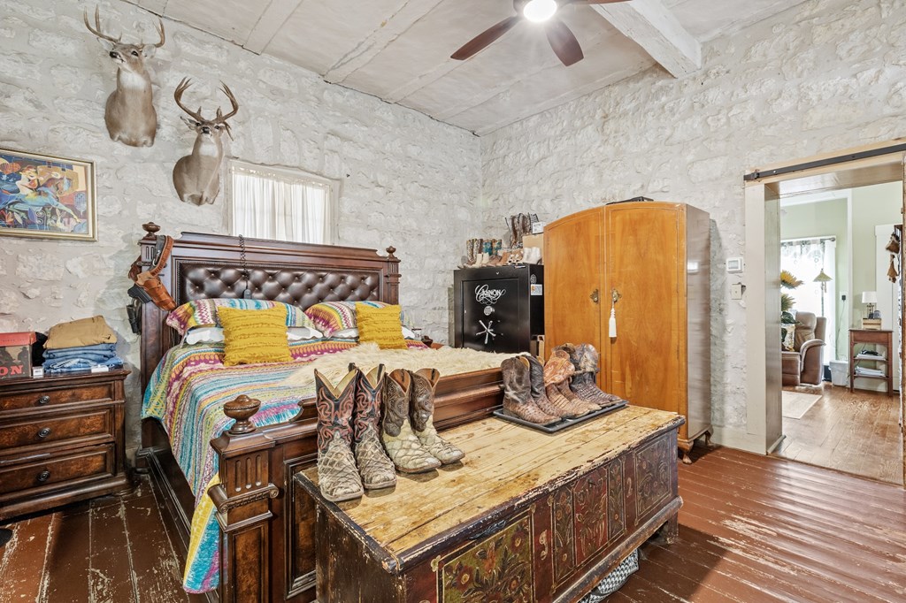 1447 Royal Oaks Loop Fredericksburg, TX 78624 - Photo 17 of 98 a bedroom with a bed and wooden floor