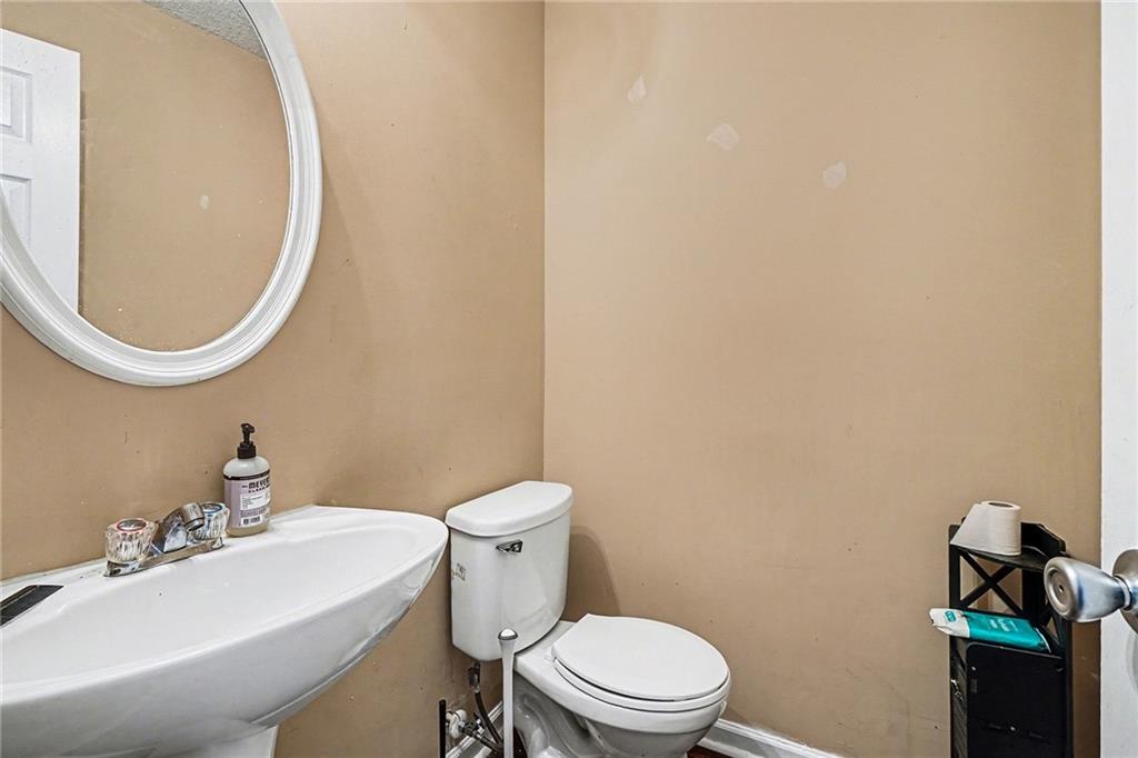 1928 Cornerstone Pass Way Conyers, GA 30012 - Photo 11 of 14 a white toilet sitting next to a bathroom sink
