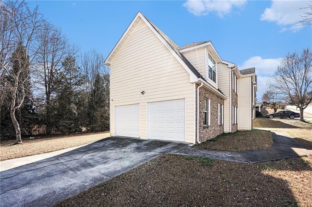 1928 Cornerstone Pass Way Conyers, GA 30012 - Photo 13 of 14 a view of a white house with a yard