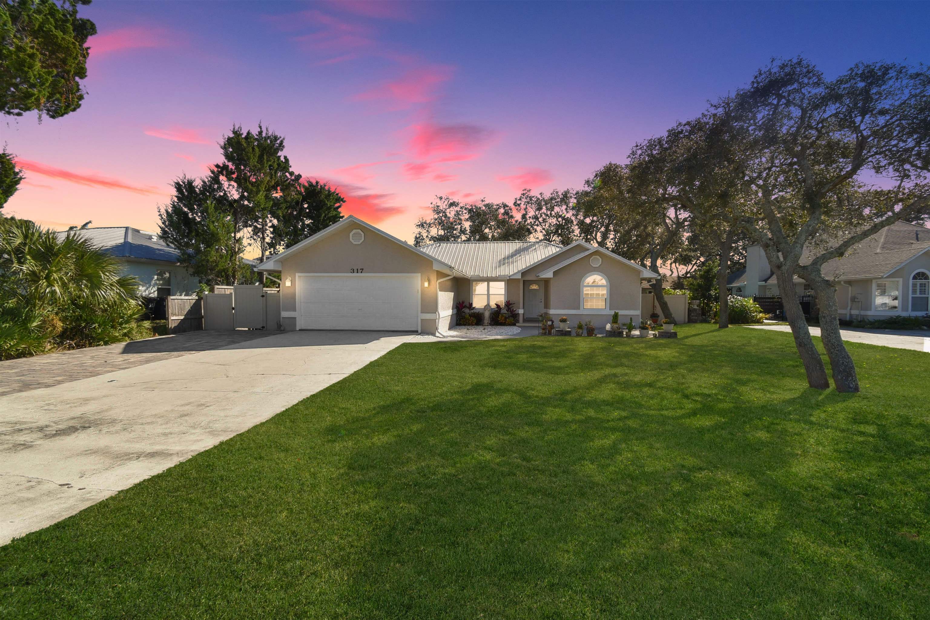 317 Mystical Way St. Augustine, FL 32080 - Photo 21 of 25 Single story home with a yard, driveway, an attached garage, a metal roof, and stucco siding