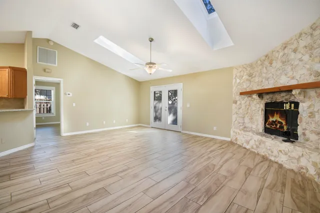 a view of a livingroom with wooden floor a fireplace and window