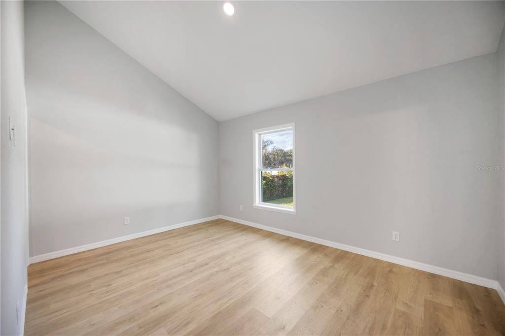 3294 West Price Boulevard North Port, FL 34286 - Photo 17 of 47 an empty room with wooden floor and windows