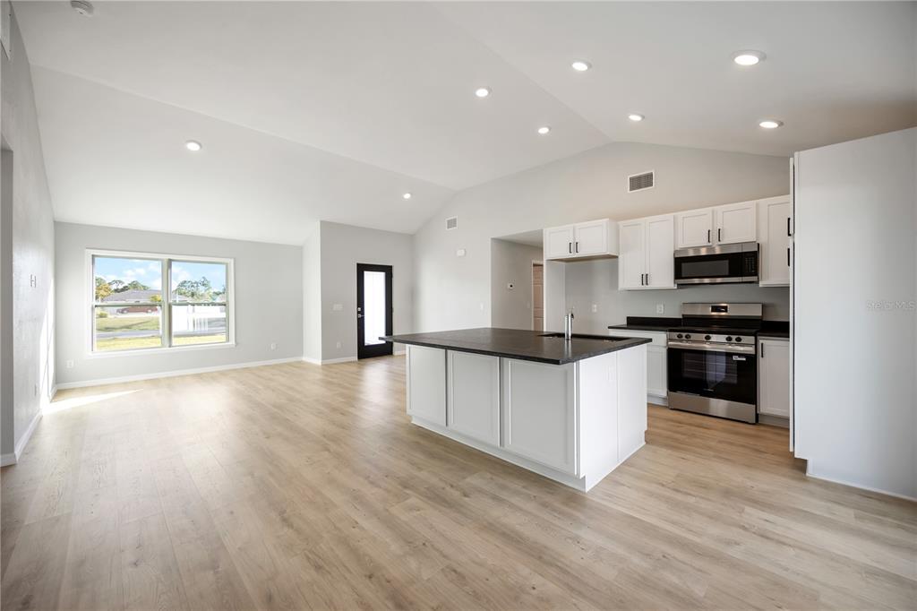 3294 West Price Boulevard North Port, FL 34286 - Photo 2 of 47 a large kitchen with stainless steel appliances granite countertop a stove and a refrigerator