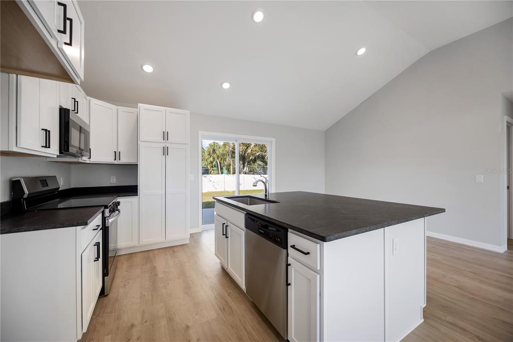 3294 West Price Boulevard North Port, FL 34286 - Photo 7 of 47 a kitchen with a sink stove and cabinets
